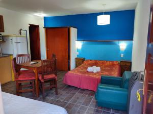 een kamer met een tafel en een blauwe muur bij En Esta Tierra in Villa Gesell