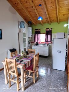 a kitchen with a table with chairs and a refrigerator at Cabana del aeropuerto calafate in El Calafate