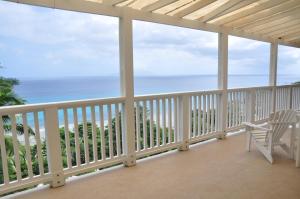 Un balcón con una silla y vistas al océano. en Bordmer House, en Glacis