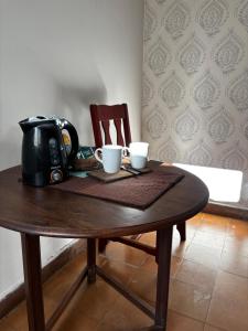a table with a tea kettle and two cups on it at El Colonial departamento céntrico in Miramar