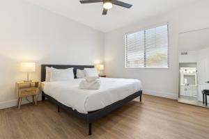 Un dormitorio blanco con una cama grande y una ventana. en CozySuites Glendale by the stadium with pool 26, en Shamrock Mobile Home Park