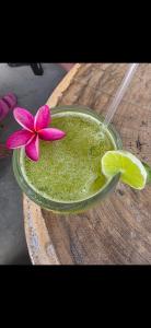 a drink with a pink flower in a bowl on a wooden table at Coco Paradiso in Mechapa