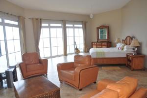 a bedroom with a bed and a couch and chairs at Bord Mer House in Glacis
