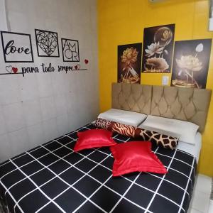 a room with a bed with red pillows on it at Aracaju Suite - Seu Conforto no Coração da Capital in Aracaju