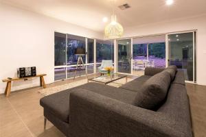 a living room with a couch and a table at Manyatta Secluded in Nature Close to Attractions in Quindalup