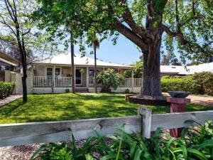 ein Haus mit einem Baum und einem Zaun in der Unterkunft Newberry Cottage - Beach, Games & Alfresco Bliss in Dunsborough
