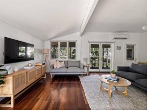 ein Wohnzimmer mit Sofa und Fernseher in der Unterkunft Newberry Cottage - Beach, Games & Alfresco Bliss in Dunsborough