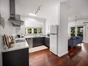 eine Küche mit einem Kühlschrank und ein Wohnzimmer in der Unterkunft Newberry Cottage - Beach, Games & Alfresco Bliss in Dunsborough