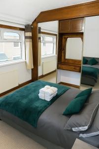 a large bed in a room with two windows at Entire luxury house Free Parking accommodations for contractors and long stays in Birmingham