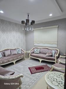 a living room with two couches and a table at شقه مؤثثة بالشوقية in An Nikāshah