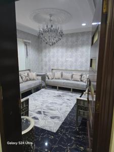 a living room with a couch and a chandelier at شقه مؤثثة بالشوقية in An Nikāshah