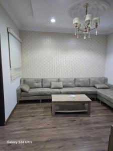 a living room with a couch and a coffee table at شقه مؤثثة بالشوقية in An Nikāshah