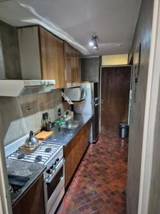 a kitchen with a sink and a stove top oven at Ubicación privilegiada!!! Plaza España in Mendoza +8 photos