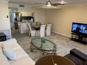 a living room with a couch and a table and a tv at Fully furnished Condo in Deerfield Beach