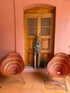 two chairs in front of a building with a door at Departamento Yotao in Oaxaca City