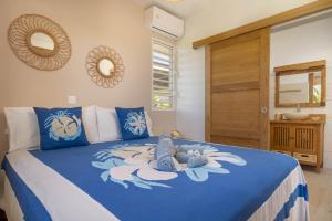 a bedroom with a bed with a blue comforter at Papara Ocean Bungalow in Papara