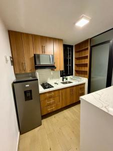 a large kitchen with wooden cabinets and a refrigerator at Depamor in Morelia