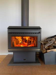 ein Ofen mit einem Feuer in einem Zimmer in der Unterkunft Someplace Else in Bonnie Doon