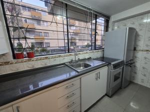 a kitchen with a sink and a refrigerator at Hermoso departamento en Viña del Mar in Viña del Mar