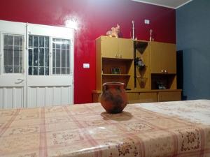 a vase sitting on top of a bed in a room at Hospedaje TAWA WASI in Tilcara
