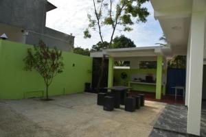 a building with a green wall with a table andools at Marino Bay Resort Kalametiya in Hambantota