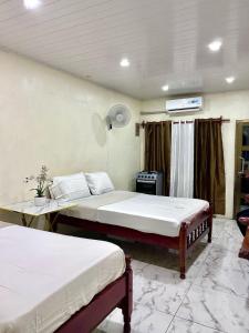 Un dormitorio con dos camas y una mesa y una ventana. en Apartamento lorena, en Altagracia