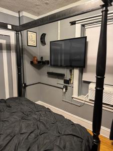 a bedroom with a bed and a flat screen tv at The Solar Lodge Albany Park, 2bdrm, 1 bath eclectic premium private apt in Chicago