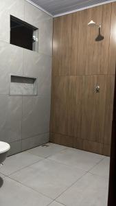 a bathroom with a toilet and a wooden wall at Casa da folha 12 in Marabá