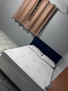 a bed in a room with a window at Casa da folha 12 in Marabá