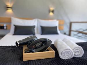 ein Hotelzimmer mit einem Telefon und Handtüchern auf einem Bett in der Unterkunft LOFT Rio 102 - Refúgio Romântico Inclusivo com Piscina Privativa - bem prox a Vilas Gastronômicas, Polo de Artesanato e Associação Peixe-boi in Pôrto de Pedras + 35 Fotos