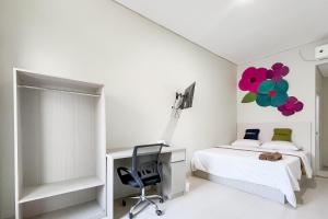 万隆Urbanview at Ra Residence Buah Batu的一间卧室，配有一张床、一张桌子和一把椅子