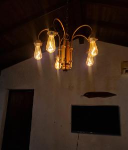 a chandelier with lights hanging from a ceiling at Casa Limoeiro 5min da ilha in Alter do Chao