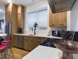 cocina con armarios de madera, fregadero y fogones en 2BR with Onsite Parking and Laundry Just 4 Min to Downtown, en Chicago