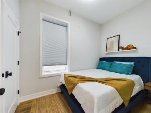 a bedroom with a blue bed and a window at West Town 2BR with In-Unit Laundry and Onsite Parking in Chicago +1 photo