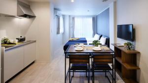 a small room with a bed and a table and chairs at Minn Kamata in Tokyo