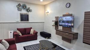 a living room with a couch and a tv at Durrani's Homestay in Mersing