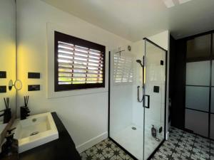 een badkamer met een glazen douche en een wastafel bij Moa Studios - Stay Waiheke in Blackpool
