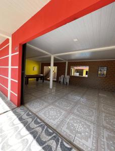 an empty room with a red wall and a table at Manga rosa Alter do Chão in Santarém