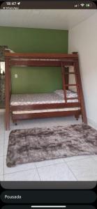 a bunk bed in a room with a green wall at Manga rosa Alter do Chão in Santarém
