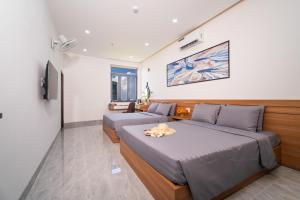 a bedroom with two beds and a tv at Binh An Motel in Danang