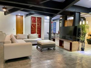 a living room with a couch and a flat screen tv at Casa Gigante de lujo, con piscina privada, 4 amplias habitaciones con baño privado in Playa del Carmen