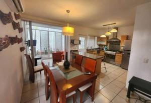 a kitchen and living room with a table and chairs at Casa en Coto amueblada in Mezcales