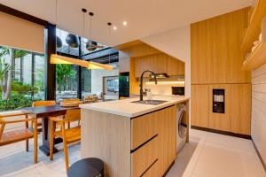 een open keuken en eetkamer met een eettafel bij Luxury 5BR Villa Byrdland Pasisi - Canggu in Canggu