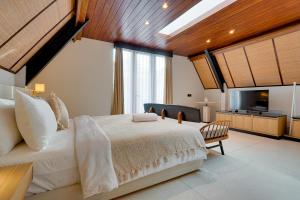 een slaapkamer met een groot bed en een televisie bij Luxury 5BR Villa Byrdland Pasisi - Canggu in Canggu +45 foto's