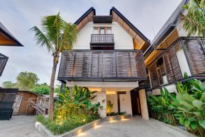 een huis met een palmboom ervoor bij Luxury 5BR Villa Byrdland Pasisi - Canggu in Canggu