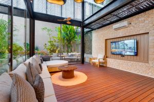 een woonkamer met een bank en een tv bij Luxury 5BR Villa Byrdland Pasisi - Canggu in Canggu