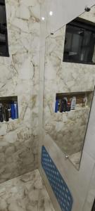 a bathroom with a marble shower with a mirror at Pousada Ruby in Irati +4 photos