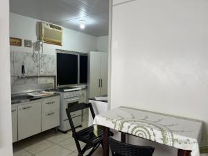 a small kitchen with a table and a microwave at Apartamento no Centro de Blumenau in Blumenau