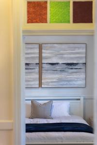 Un dormitorio con dos cuadros encima de una cama. en Seabreeze Luxury Beach House Kiama, en Kiama