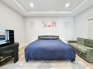 a bedroom with a bed and a couch and a tv at #Marbella Lane - Spacious 4BR Modern Family Home! in Placentia